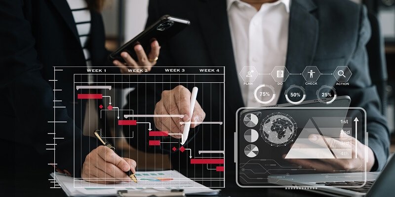 Business team hand Project manager working and update tasks and Gantt chart scheduling virtual diagram.with smart phone, tablet and laptop in office.